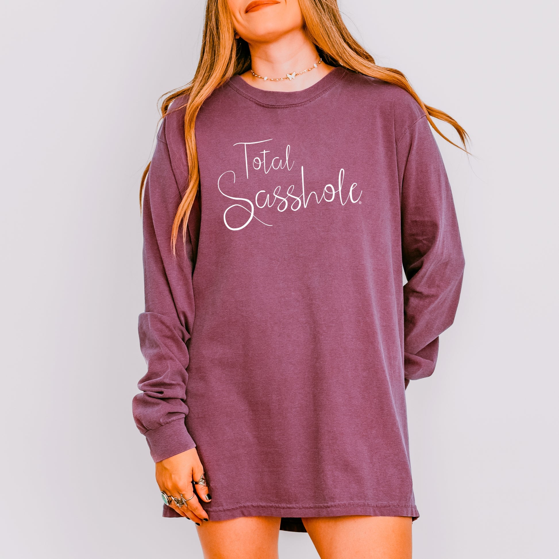 Berry long-sleeve shirt with 'Total Sasshole' text worn by a person on a plain background