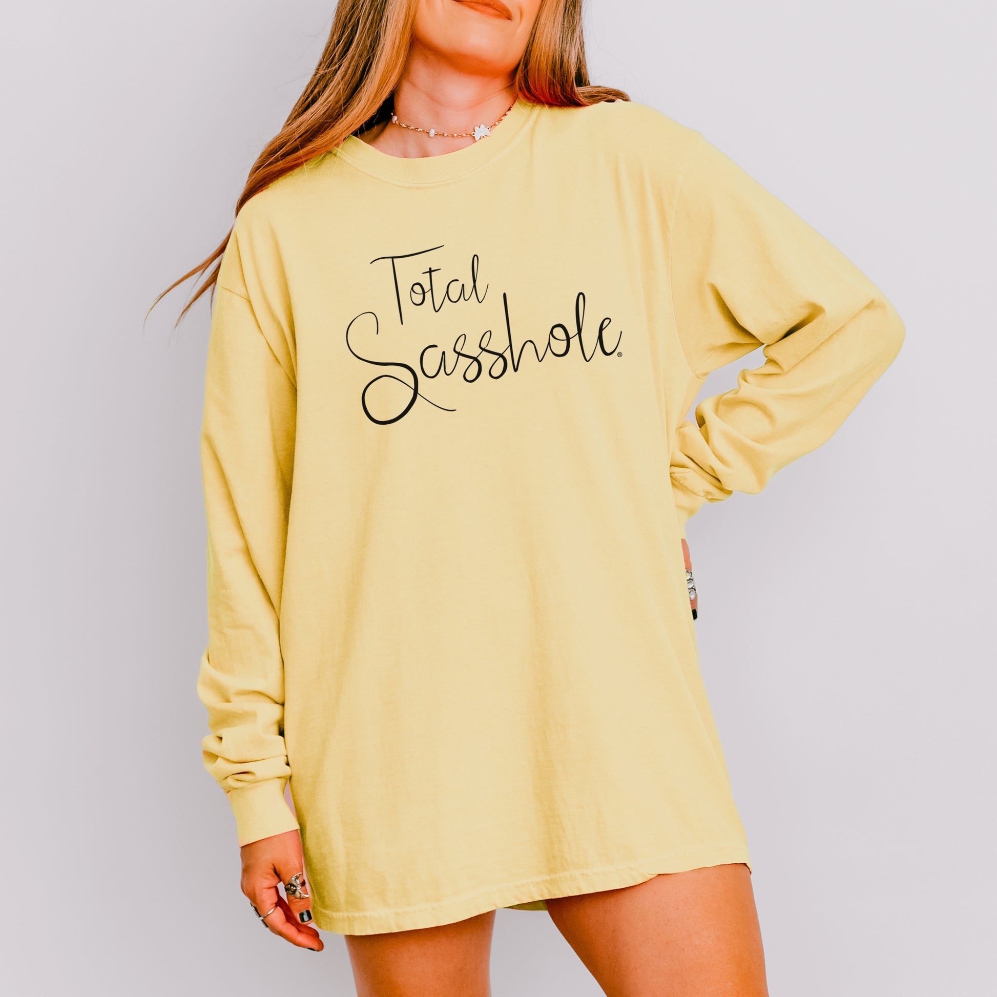 Woman wearing a Butter long-sleeve t-shirt with 'Total Sasshole' text on a plain background