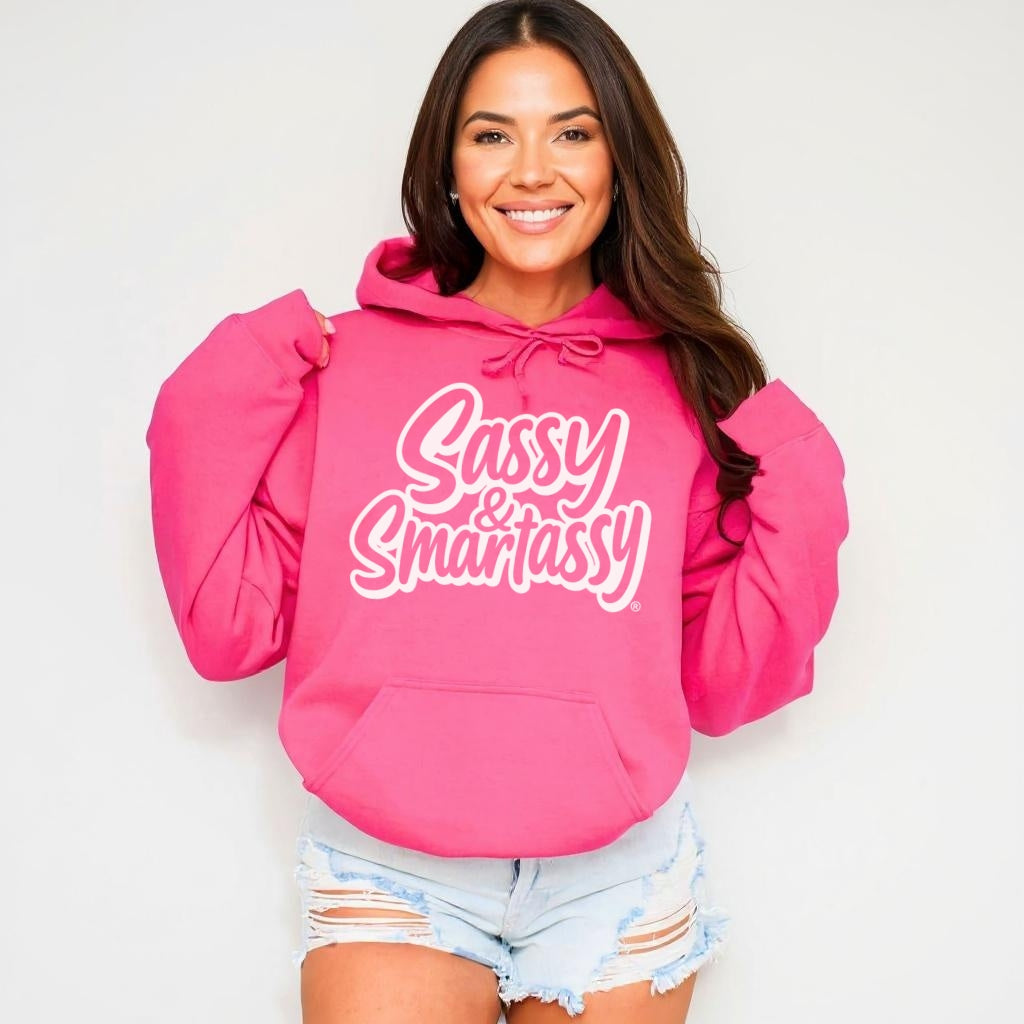 Image of Woman wearing a hot pink hoodie with 'Sassy & Smartassy' text, sitting on a white couch.