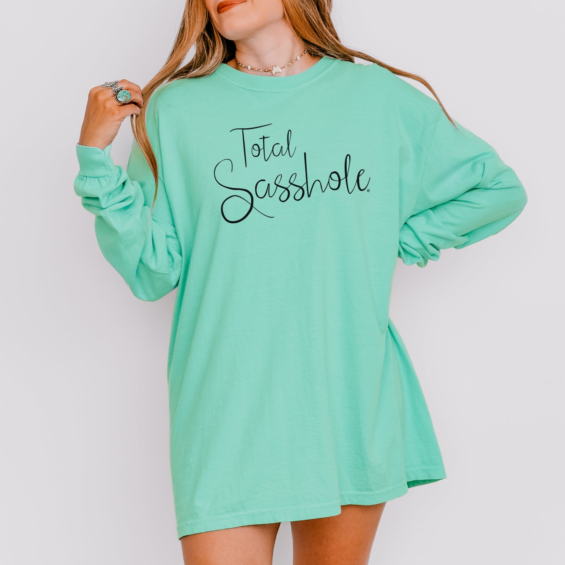 Woman wearing a island reef green long-sleeve shirt with text on a plain background