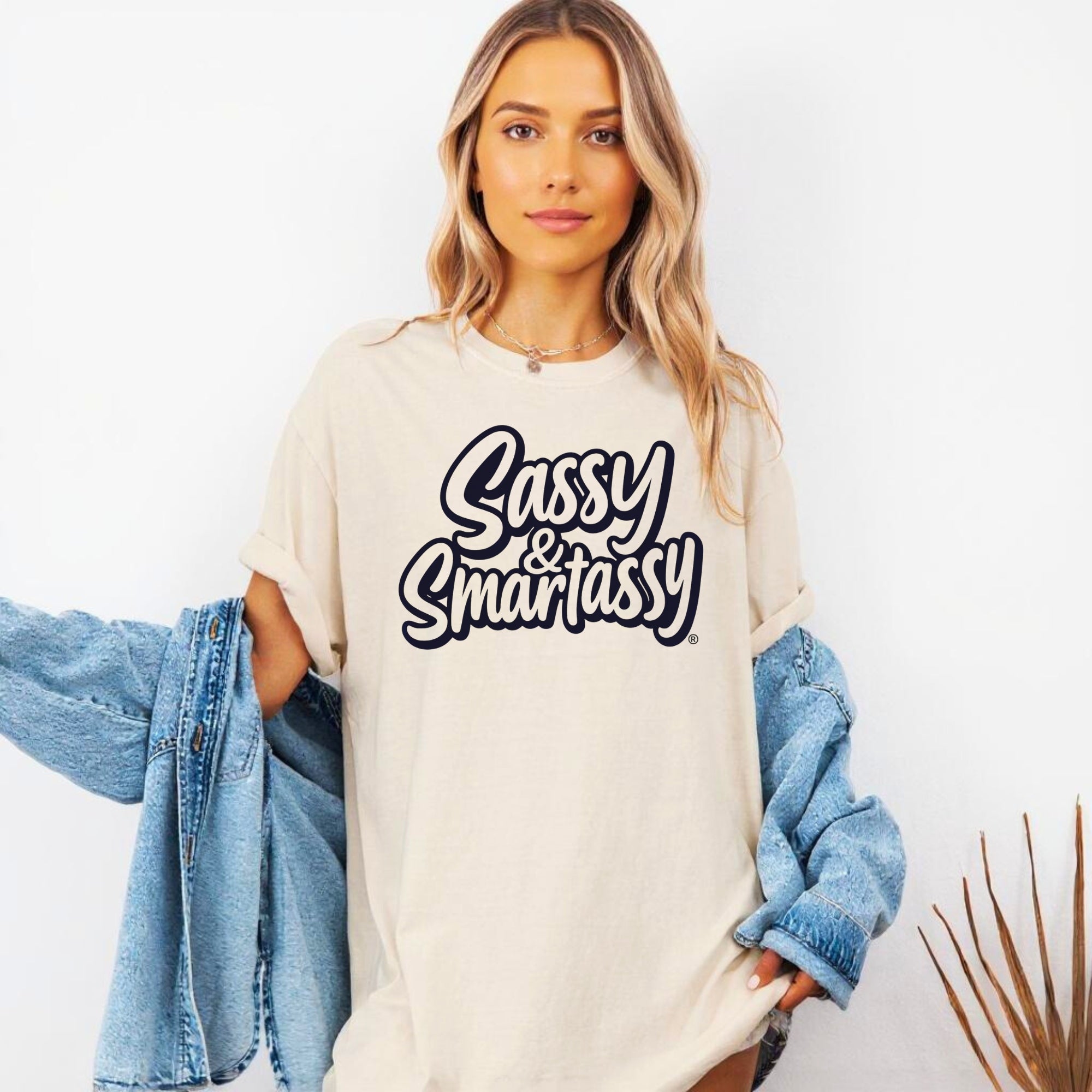 Woman wearing a 'Sassy & Smartassy' t-shirt with a denim jacket on a white background