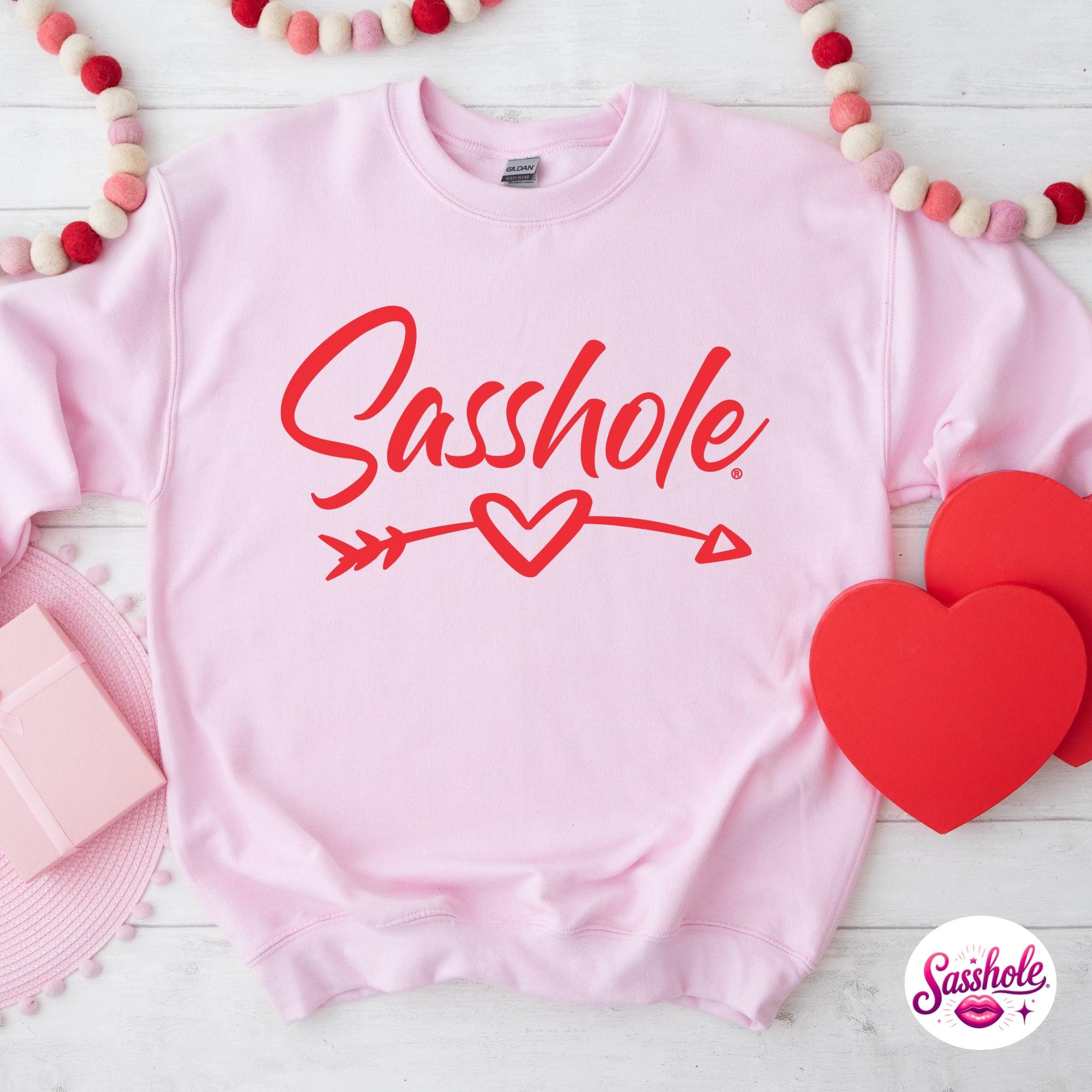 Image of Pink sweatshirt with 'Sasshole' text and heart design on a white background