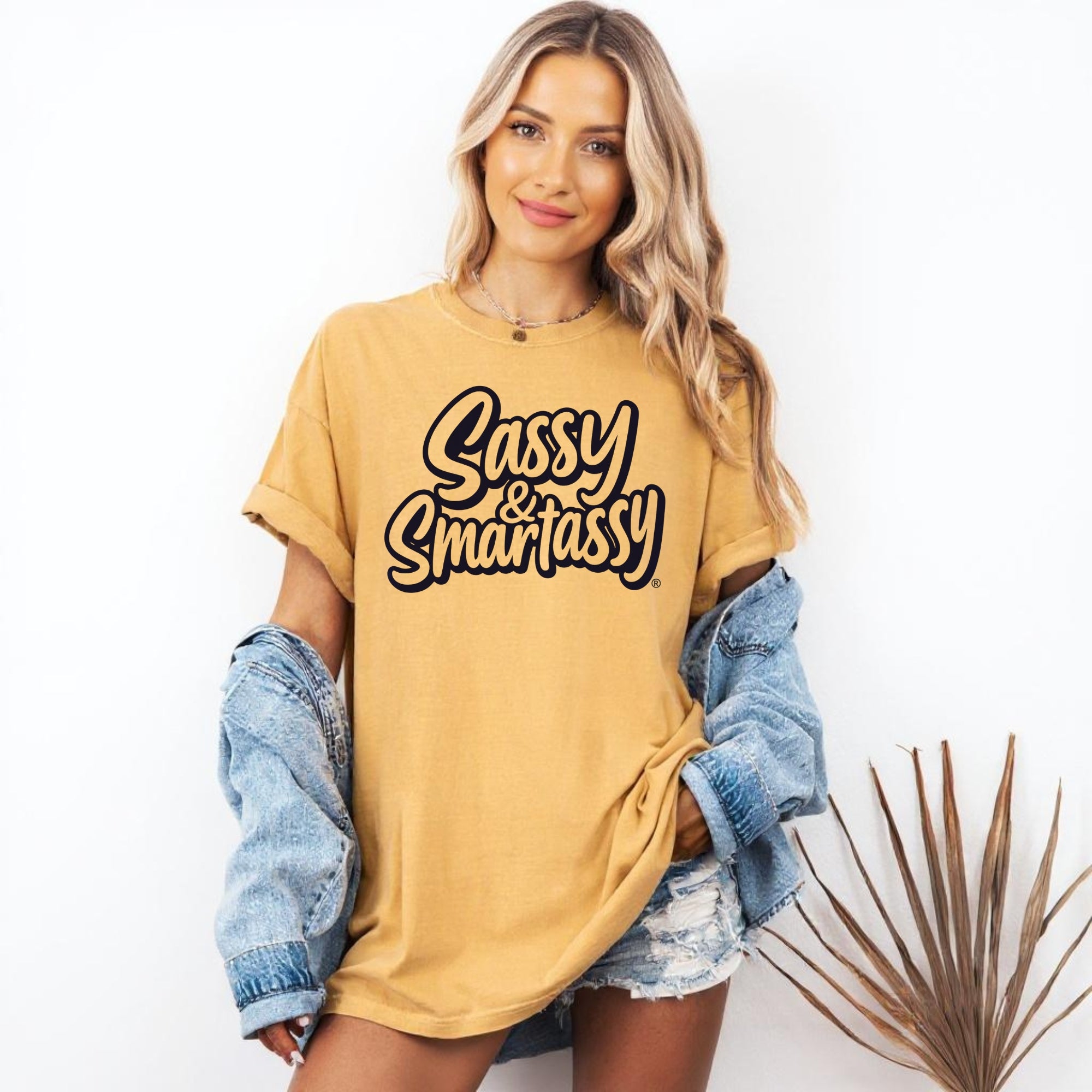 Image of Woman wearing a mustard yellow t-shirt with 'Sassy & Smartassy' text, standing against a white background.