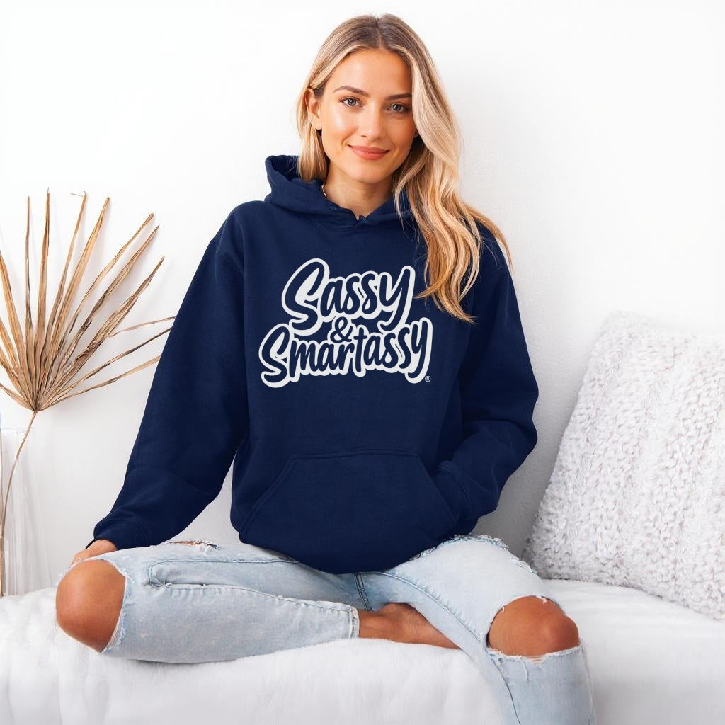 Image of Woman wearing a navy hoodie with 'Sassy & Smartassy' text, sitting on a white couch.