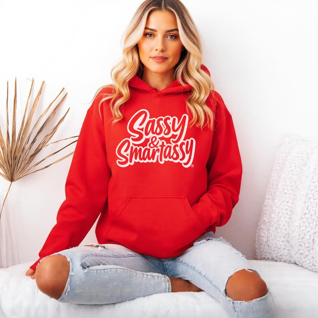 Person wearing a red hoodie with 'Sassy & Smartassy' text, sitting on a white couch.