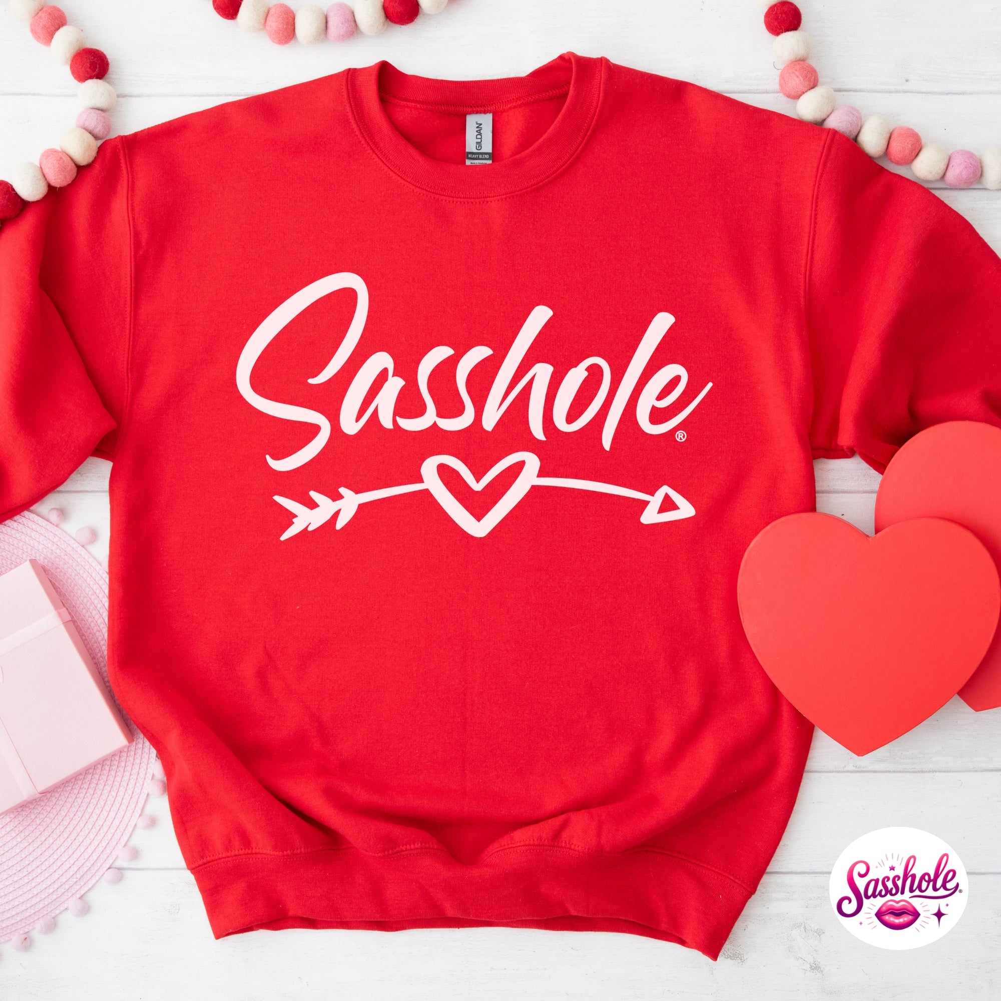 Image of Red sweatshirt with 'Sasshole' text and heart design on a white background