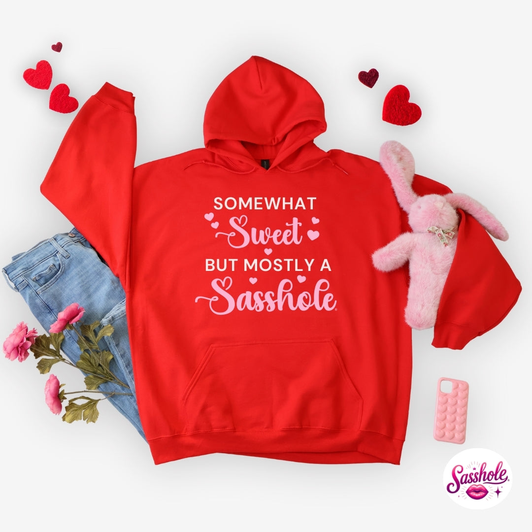 Red hoodie with humorous text, surrounded by casual items on a white background