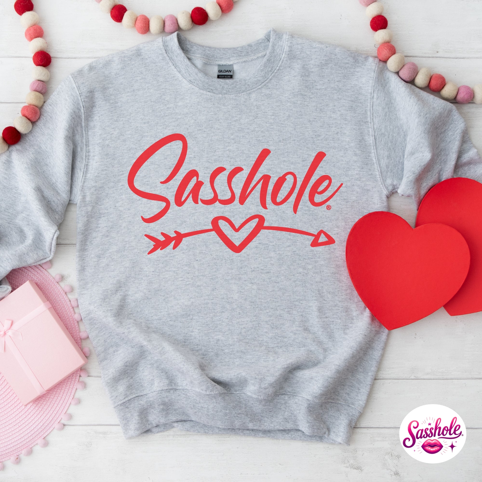 Image of Gray sweatshirt with 'Sasshole' text and red hearts on a white background