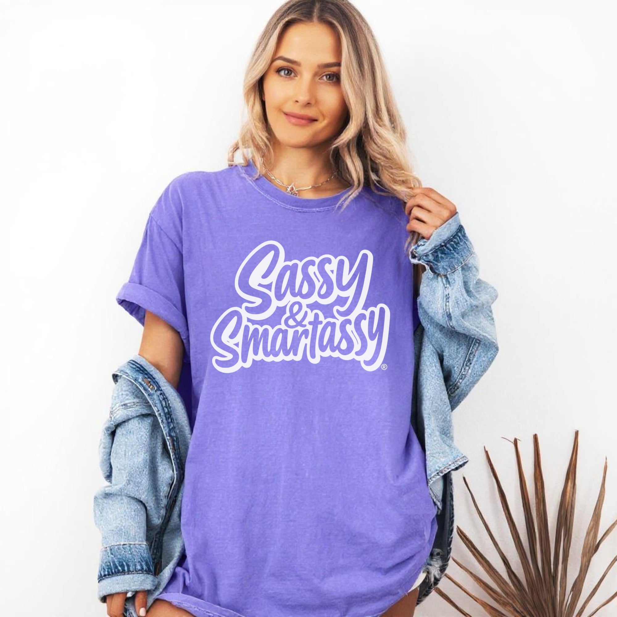 Woman wearing a purple 'Sassy & Smartassy' t-shirt with a denim jacket.