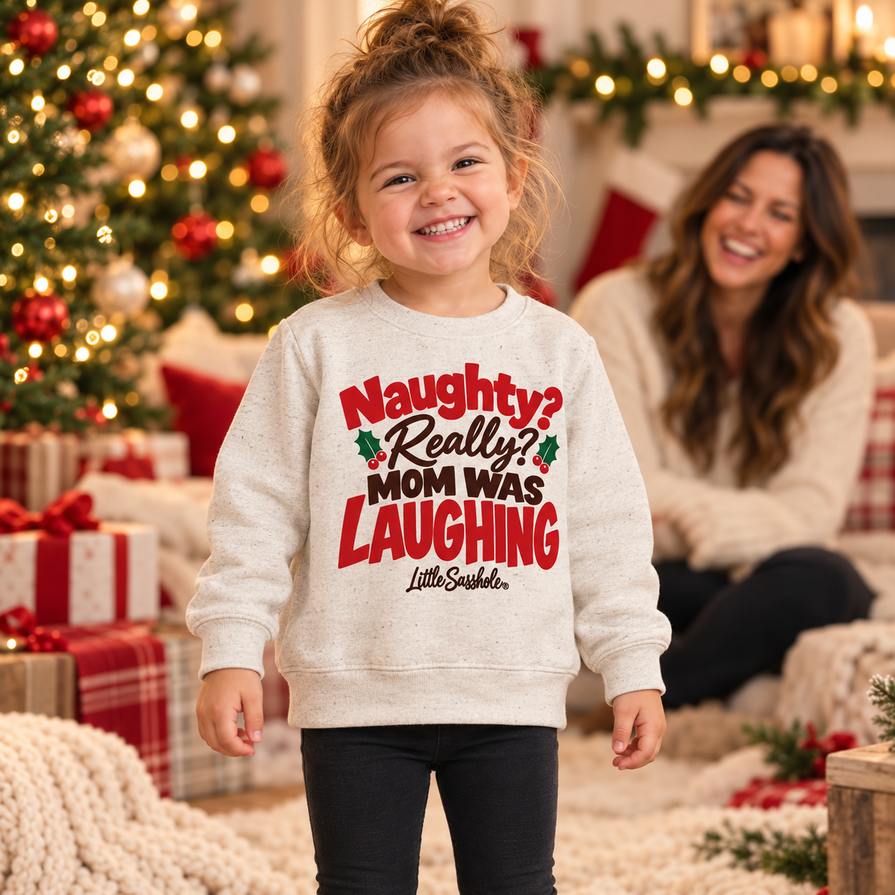 Image of Toddler wearing the Natural Heather Mom Was Laughing Christmas sweatshirt with her mother smiling behind her.