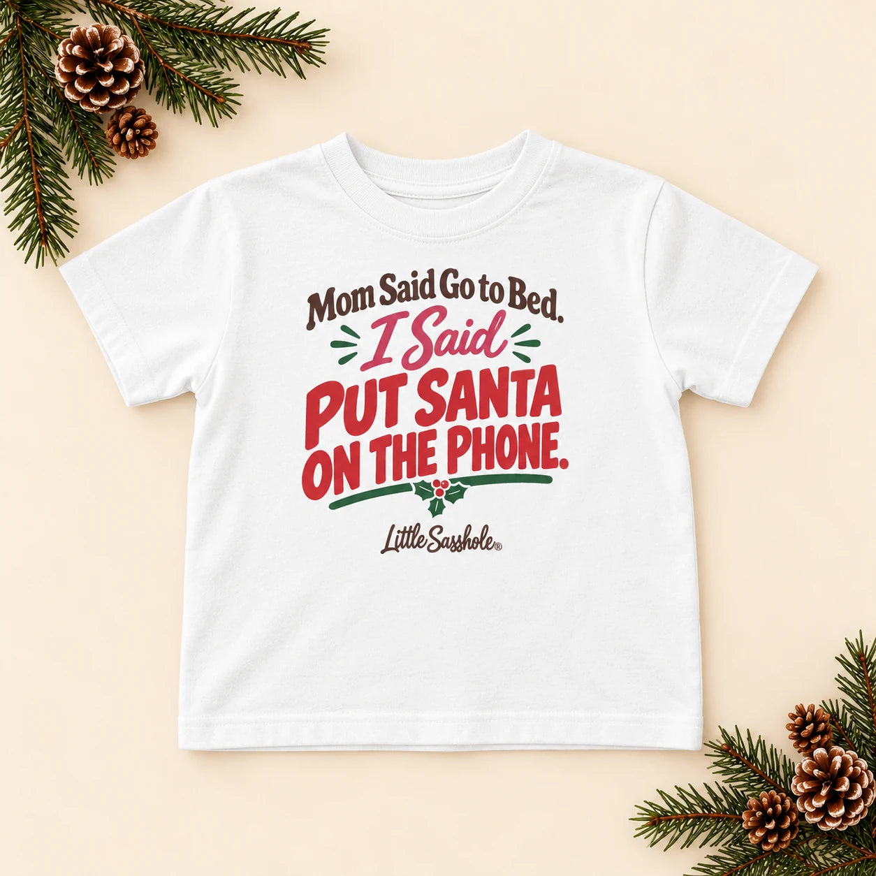 Image of Mom Said Go to Bed. I Said Put Santa on the Phone. — Toddler Graphic Tee — festive product flat lay