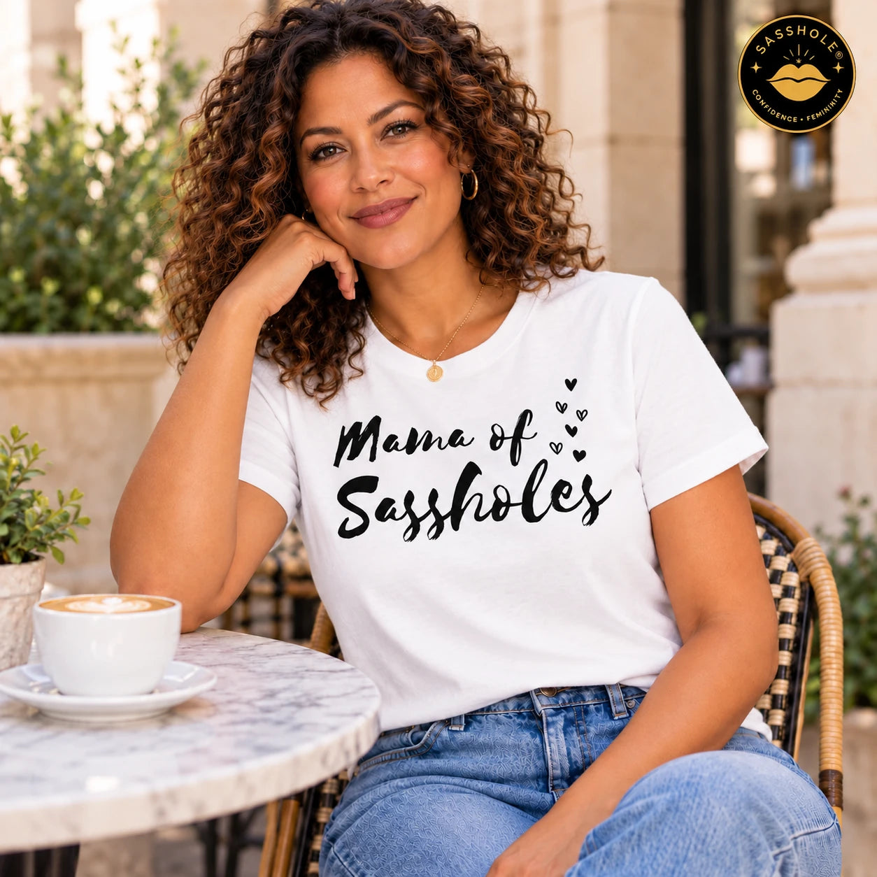 Image of Mama of Sassholes tee in White worn at an outdoor cafe.