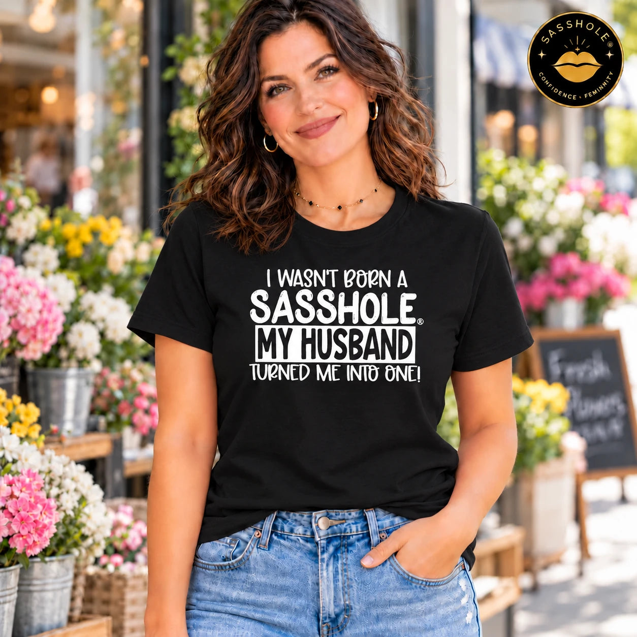 Image of I Wasn’t Born a Sasshole, My Husband Turned Me Into One! Bella+Canvas 3001 tee in Black, lifestyle front view.