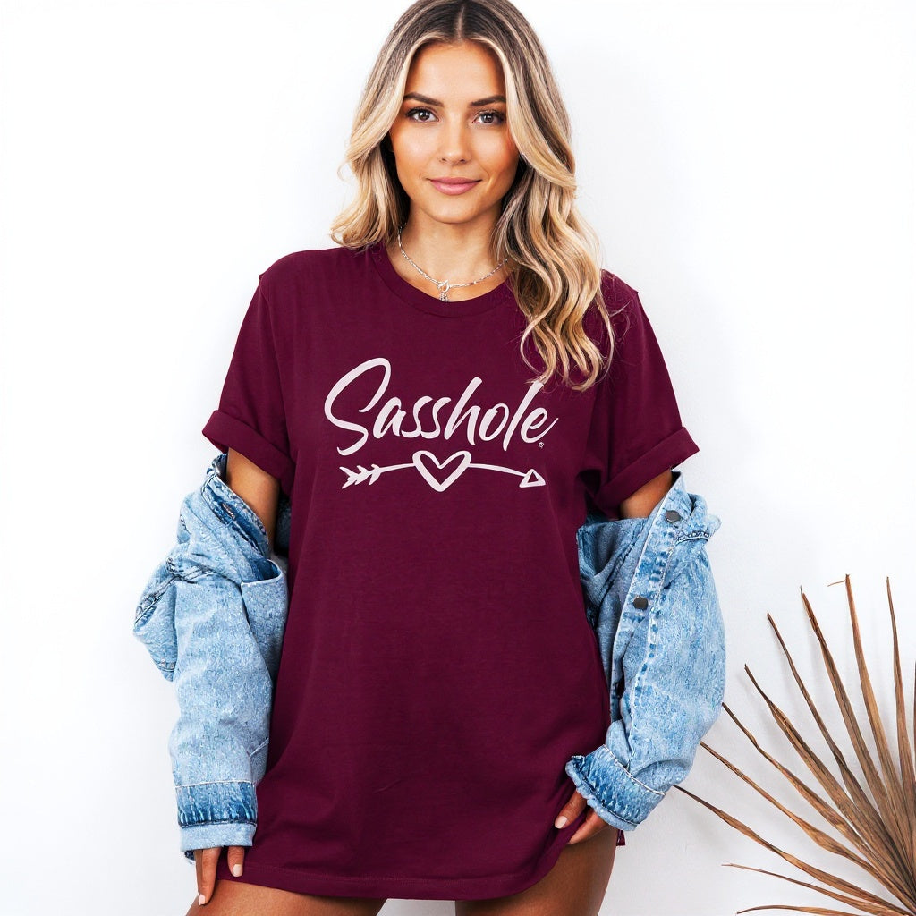 Woman wearing a maroon t-shirt with 'Sasshole' text, standing against a white background.